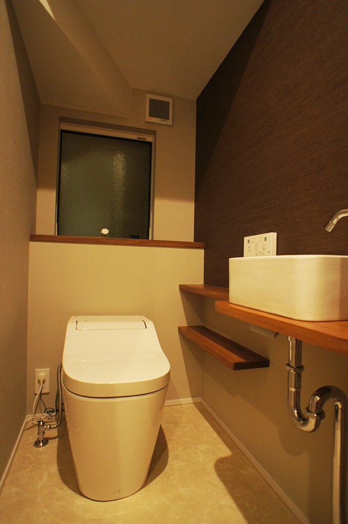 階段下を利用した1階トイレ。手洗器に安易な既製品を使わずイタリア製の洗面陶器を使用