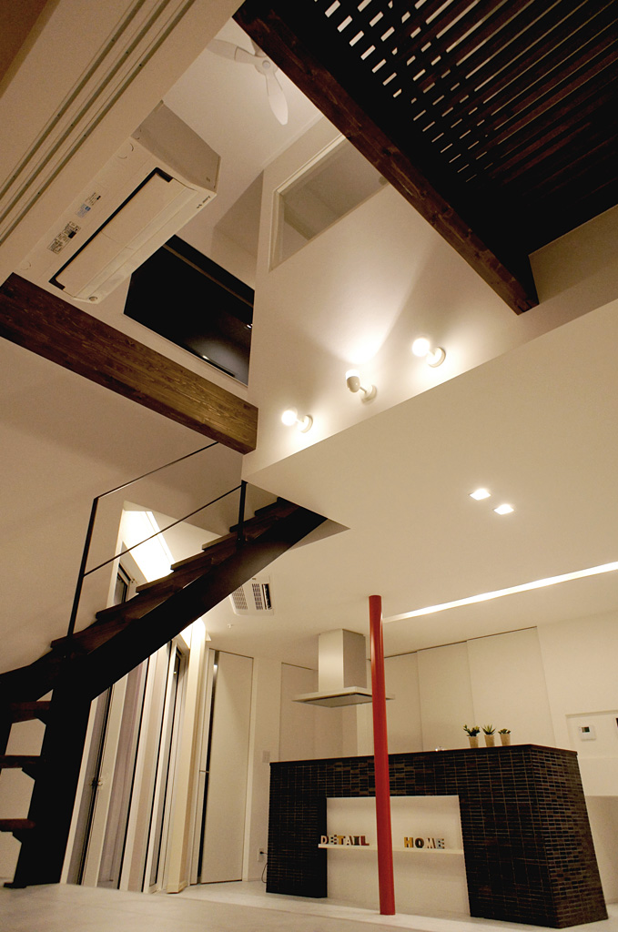 ブラックウォールナット色の梁や階段材が白い空間の中で落ち着いた素材感を出している。