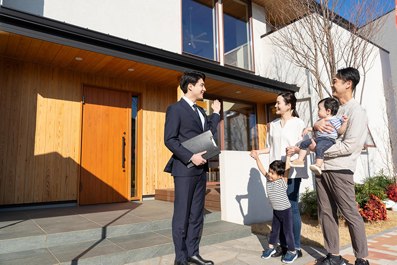 家の説明をする営業担当者と家族