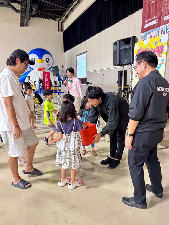 オーナー様感謝祭の抽選会で景品を受け取る子ども